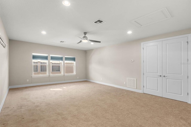 spare room with light colored carpet and ceiling fan