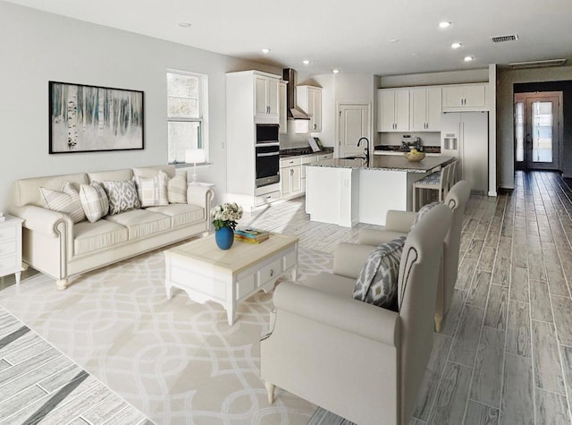 living area featuring recessed lighting, visible vents, and wood tiled floor