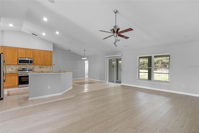 kitchen featuring appliances with stainless steel finishes, tasteful backsplash, vaulted ceiling, ceiling fan, and decorative light fixtures