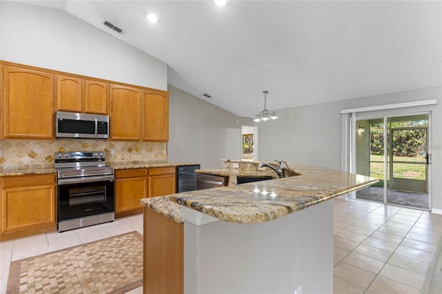 kitchen featuring a kitchen island with sink, sink, vaulted ceiling, decorative light fixtures, and stainless steel appliances