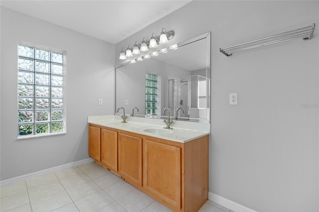 bathroom featuring tile patterned flooring, vanity, a healthy amount of sunlight, and walk in shower