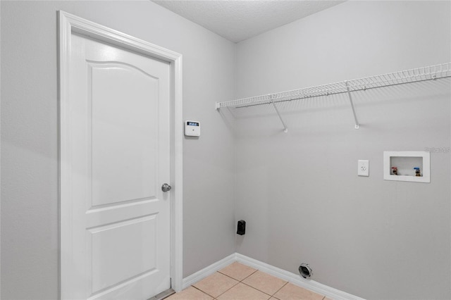 washroom featuring light tile patterned floors, washer hookup, a textured ceiling, and hookup for an electric dryer