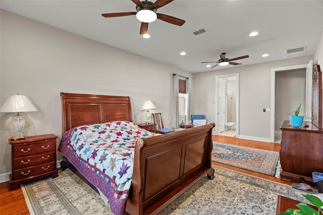 bedroom featuring wood-type flooring, ensuite bath, and ceiling fan