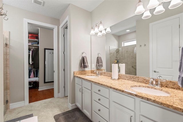 bathroom featuring vanity, tile patterned floors, and walk in shower