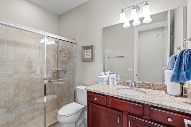 bathroom with vanity, a shower with shower door, and toilet