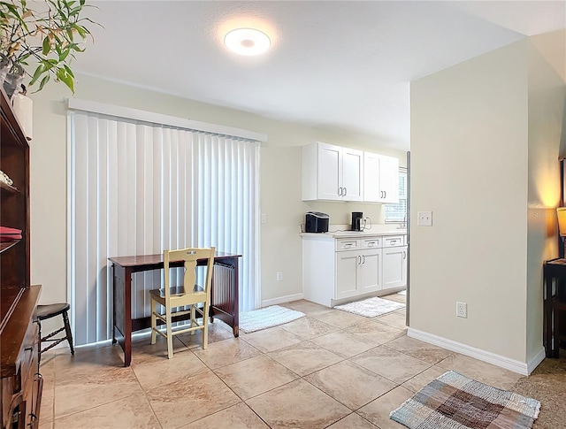 kitchen with white cabinetry and light tile patterned floors