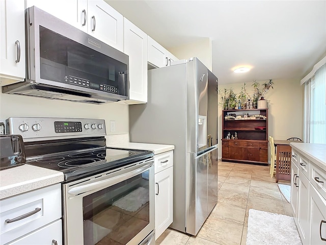 kitchen with white cabinets, light tile patterned floors, and stainless steel appliances