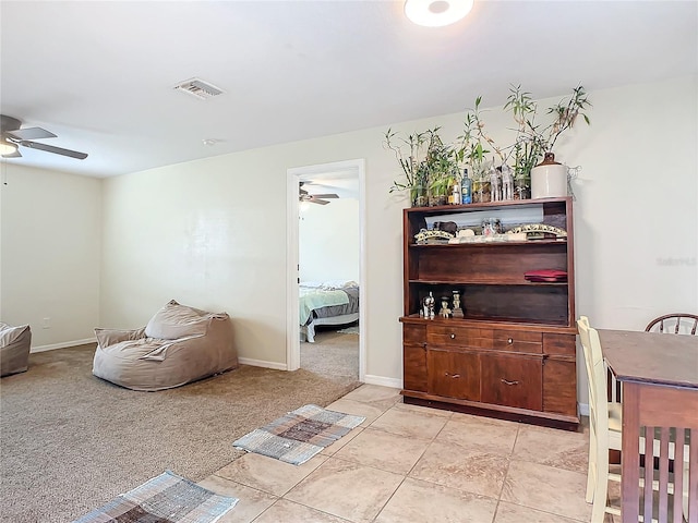 interior space featuring ceiling fan and light colored carpet