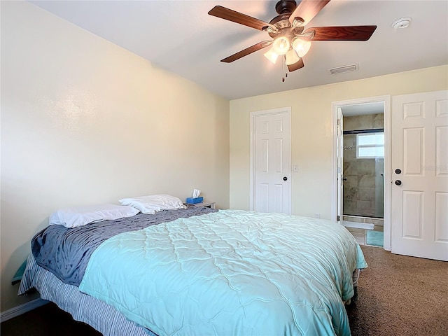 carpeted bedroom with ensuite bathroom and ceiling fan