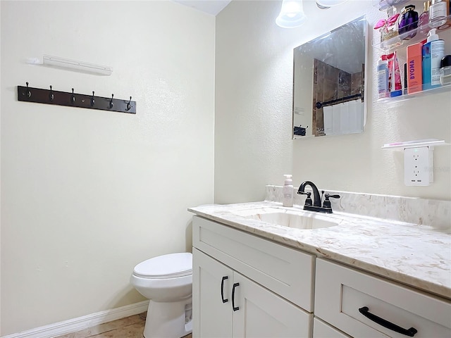 bathroom featuring tile patterned flooring, vanity, and toilet