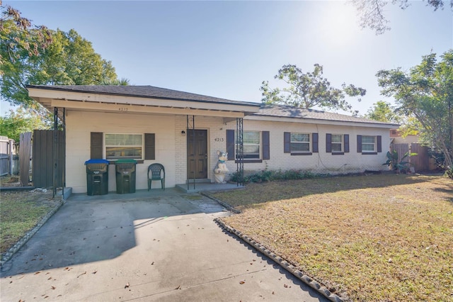 ranch-style house featuring covered porch and a front yard