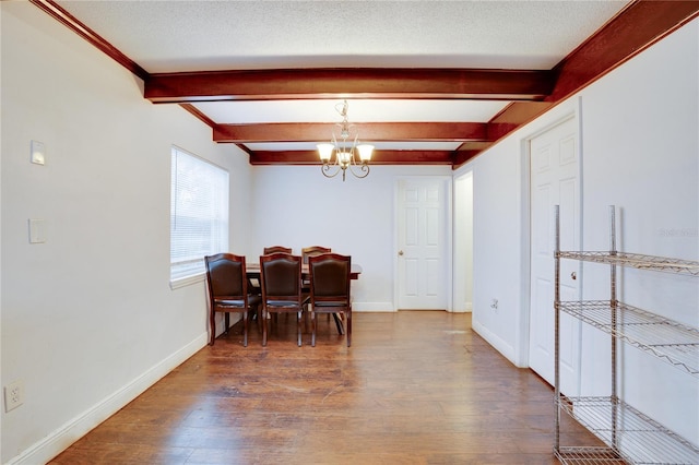 dining area featuring beam ceiling, a notable chandelier, and hardwood / wood-style flooring