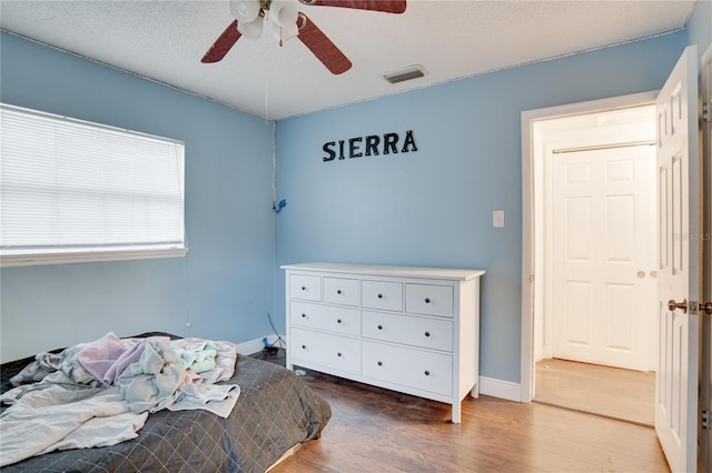 bedroom featuring a textured ceiling, ceiling fan, and hardwood / wood-style flooring