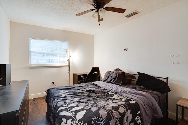 bedroom featuring ceiling fan, dark hardwood / wood-style flooring, and a textured ceiling