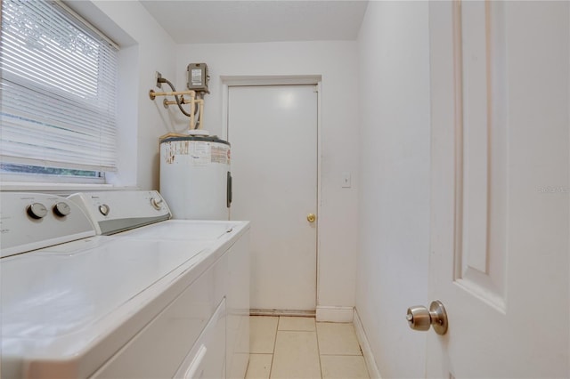 washroom with water heater, washer and dryer, and light tile patterned flooring