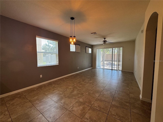1570 Fox Grape Loop, Lutz, FL 33558 - tiled spare room featuring visible vents, arched walkways, baseboards, and ceiling fan