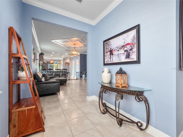 corridor featuring an inviting chandelier, light tile patterned floors, and crown molding