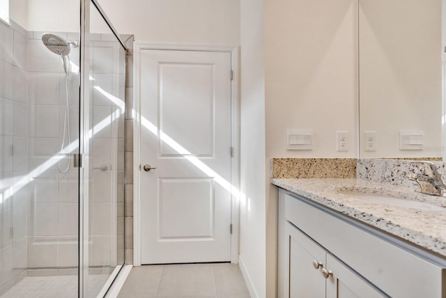 bathroom featuring tile patterned flooring, vanity, and a shower with door