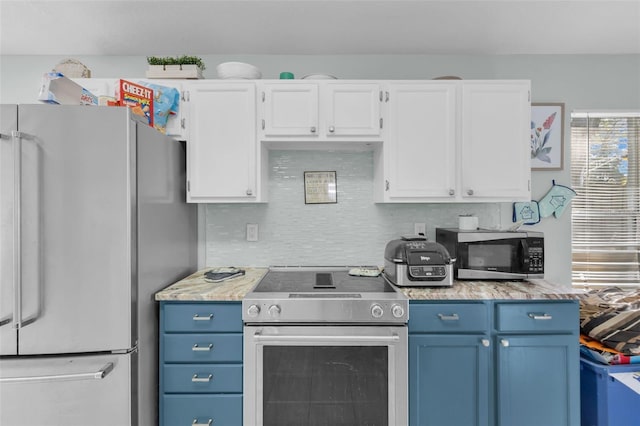 kitchen with decorative backsplash, white cabinetry, blue cabinetry, and appliances with stainless steel finishes