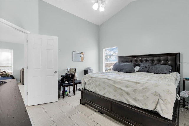 bedroom with ceiling fan and high vaulted ceiling