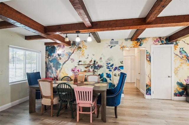 dining area with light hardwood / wood-style flooring and beamed ceiling