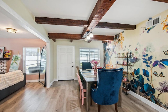 dining area with beam ceiling and light hardwood / wood-style flooring