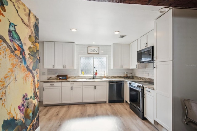 kitchen with backsplash, sink, black appliances, light hardwood / wood-style floors, and white cabinetry