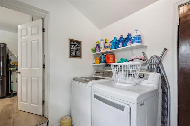 laundry room featuring washing machine and dryer and light hardwood / wood-style flooring