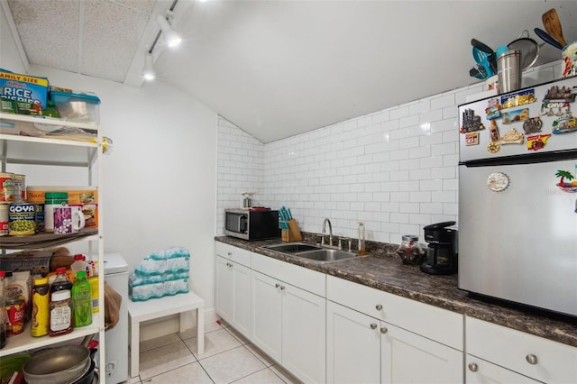 kitchen with sink, light tile patterned floors, white cabinets, tile walls, and appliances with stainless steel finishes