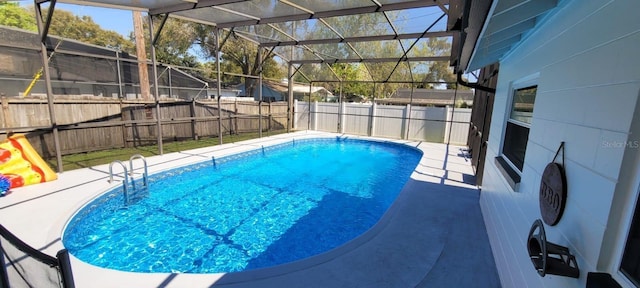 view of pool featuring glass enclosure and a patio area