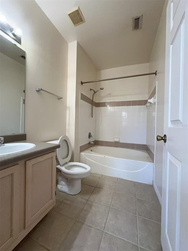 full bathroom featuring toilet, vanity, tiled shower / bath combo, and tile patterned floors