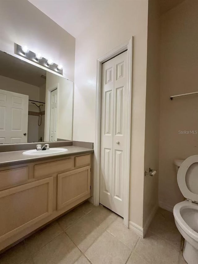 bathroom with tile patterned flooring, vanity, and toilet