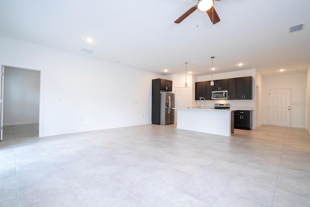 unfurnished living room with ceiling fan and sink