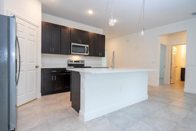 kitchen featuring pendant lighting, light tile patterned floors, an island with sink, appliances with stainless steel finishes, and dark brown cabinets