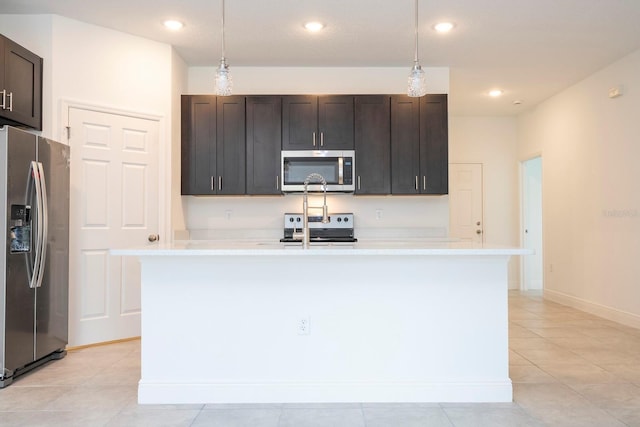 kitchen featuring dark brown cabinets, stainless steel appliances, a kitchen island with sink, light tile patterned floors, and decorative light fixtures