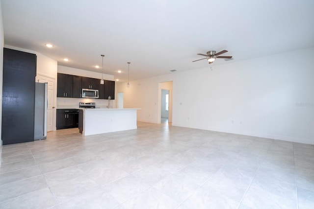 kitchen with pendant lighting, ceiling fan, a center island, and stainless steel appliances