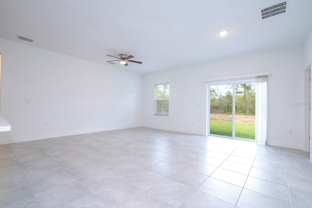 tiled spare room with ceiling fan