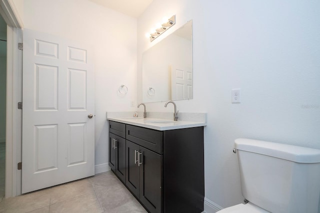 bathroom with tile patterned flooring, vanity, and toilet