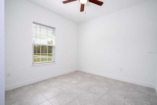 tiled empty room featuring ceiling fan