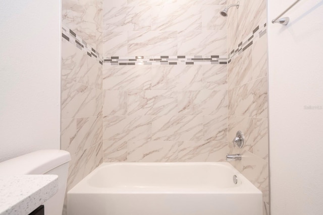 bathroom with toilet and tiled shower / bath