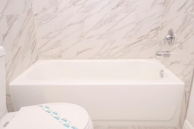 bathroom featuring toilet and a tub