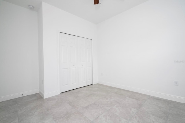 unfurnished bedroom featuring ceiling fan, light tile patterned floors, and a closet