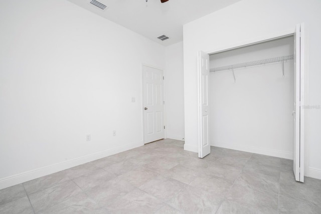 unfurnished bedroom with ceiling fan and a closet