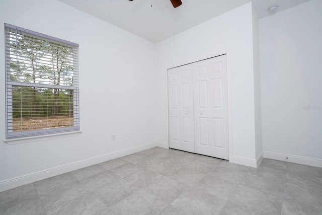 unfurnished bedroom featuring ceiling fan and a closet