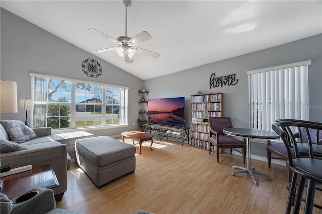 living room with ceiling fan, light hardwood / wood-style floors, and lofted ceiling