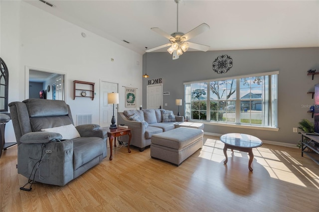 living room featuring ceiling fan, lofted ceiling, and light hardwood / wood-style flooring