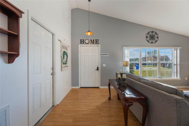 foyer with light hardwood / wood-style floors and lofted ceiling