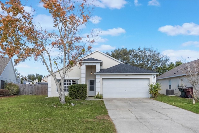 view of front of property featuring a garage, central air condition unit, and a front yard