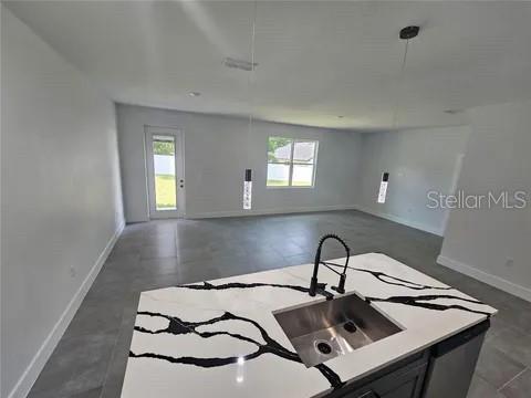 kitchen with a wealth of natural light, open floor plan, light countertops, and decorative light fixtures