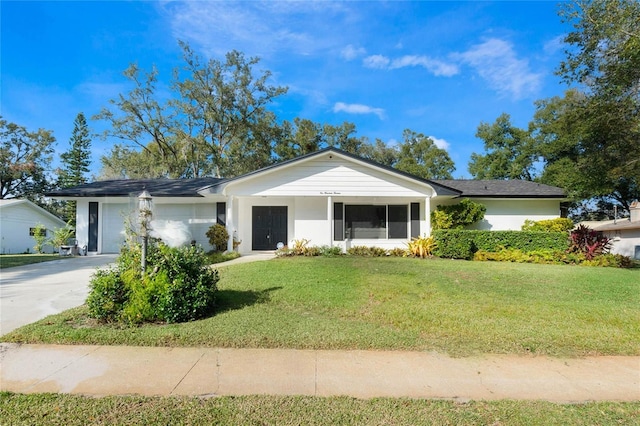 ranch-style home featuring a garage and a front lawn